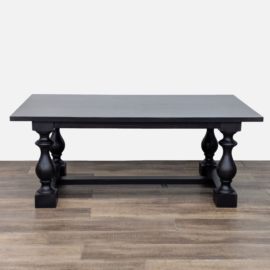 Rectangular Restoration Hardware dining table with wood veneer top and sculpted baluster trestle legs, no chairs.