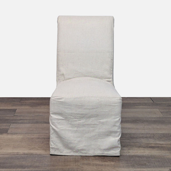 1. Front view of a Pottery Barn Hudson dining chair with a light slipcover, shown on wood flooring.
