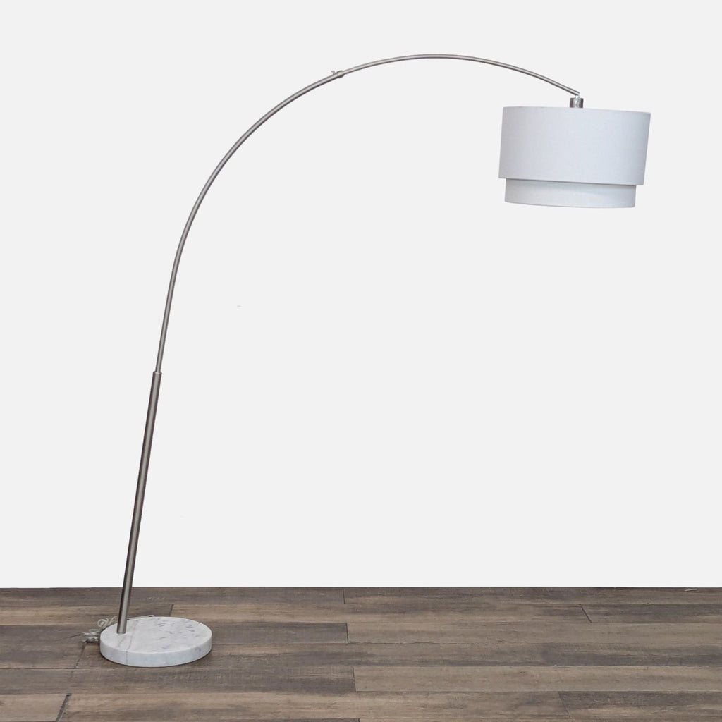 Modern arc floor lamp with a curved metal arm and a white fabric shade.