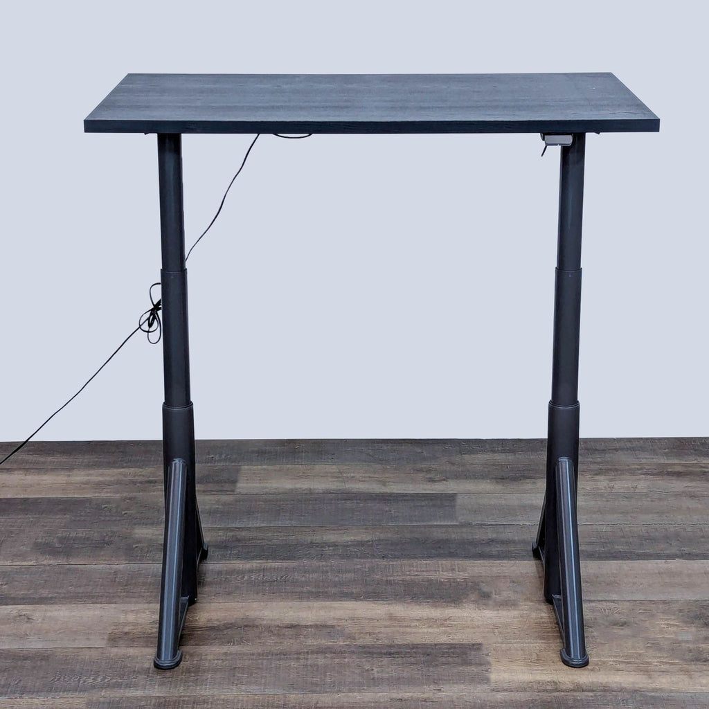 Sleek standing desk, height adjustable for ergonomic use with cable netting.
