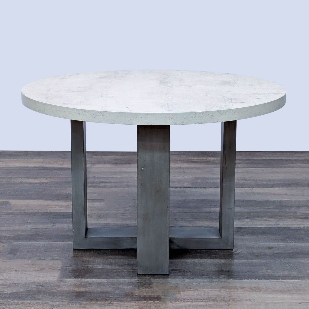Round kitchen table with a concrete laminate top and sturdy base for heat resistance.