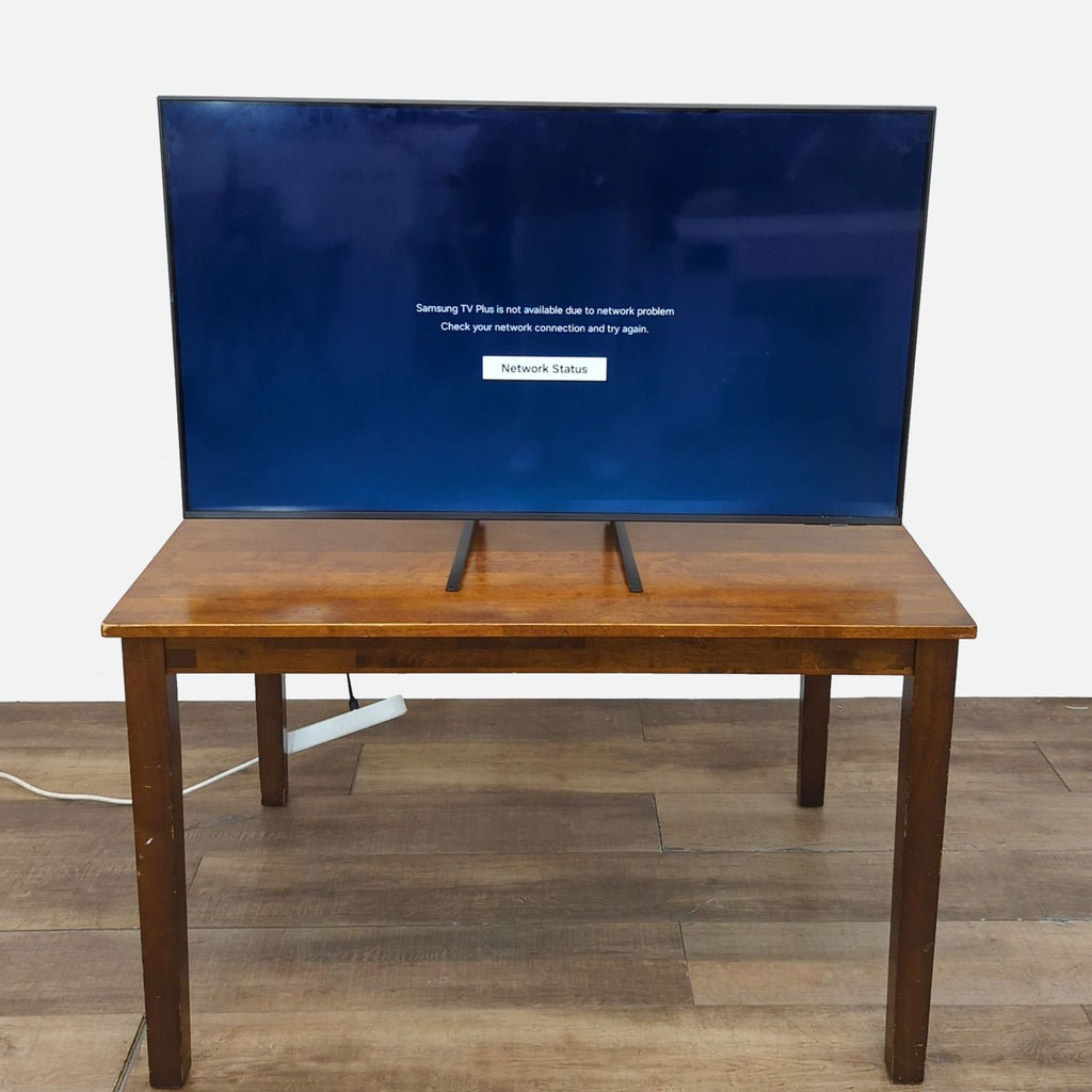 Samsung 55" Smart LED TV on a wooden table, displaying a network error screen.