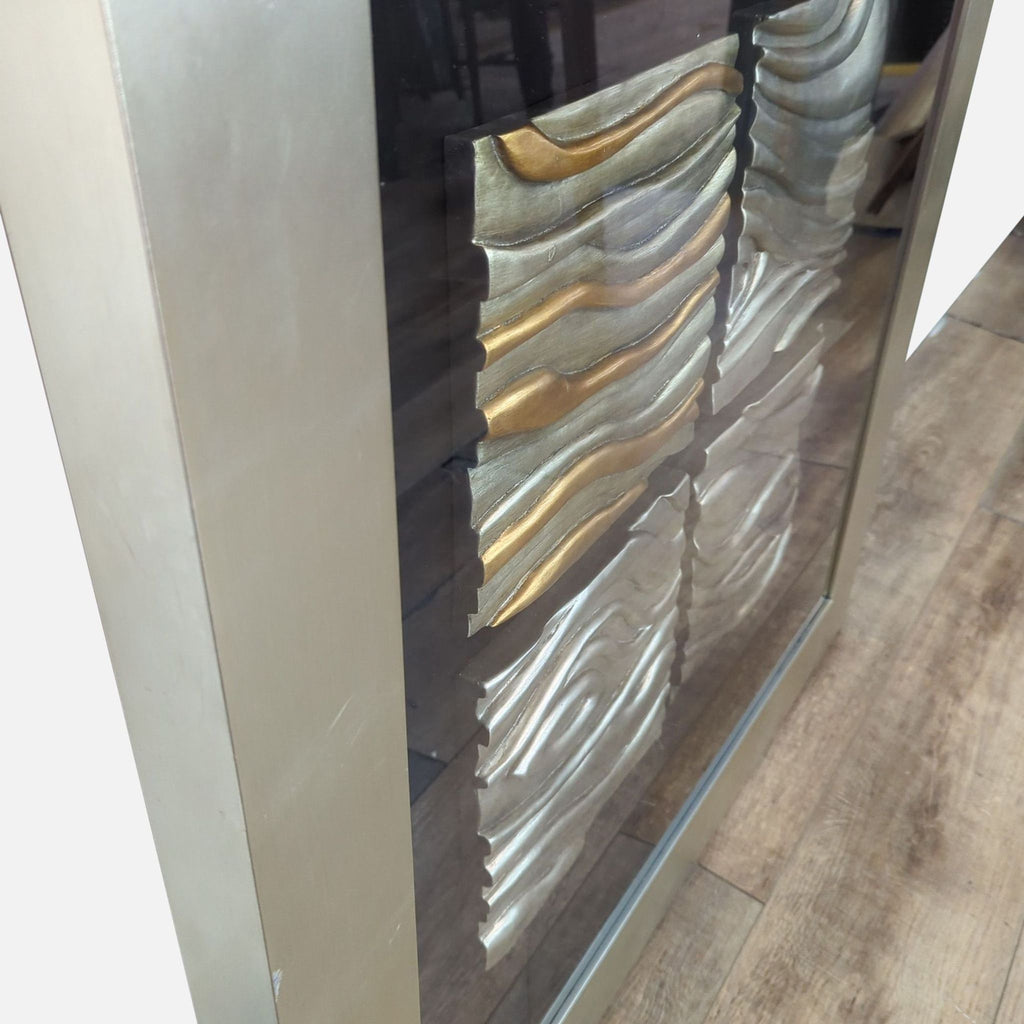 Close-up of a decorative panel showing gold and silver wavy patterns.
