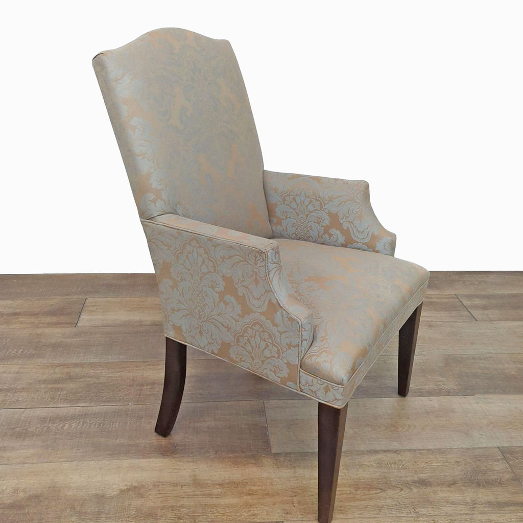 Side view of an upholstered dining chair with ornate pattern.