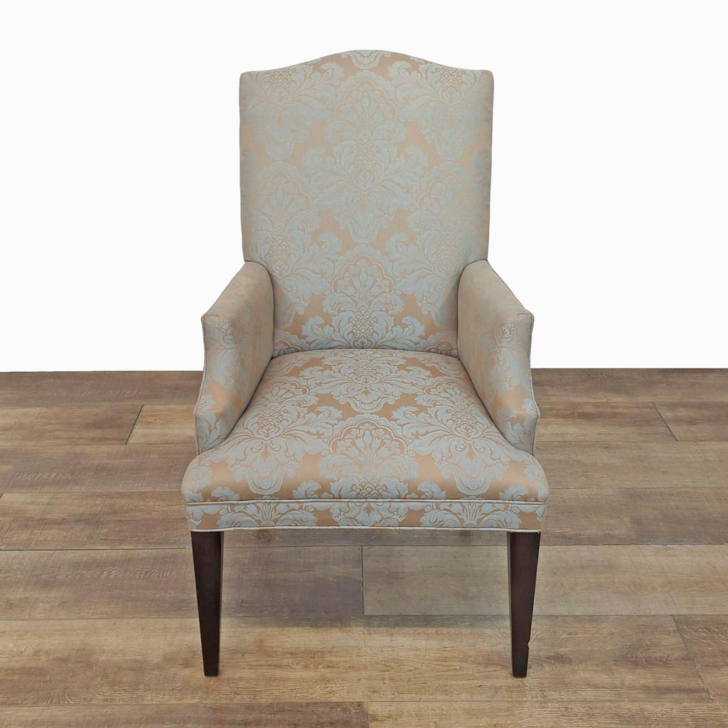 Elegant dining chair with patterned upholstery and dark wooden legs.