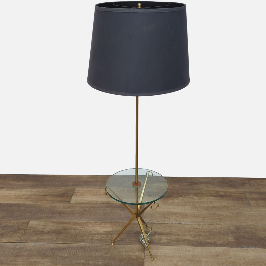 Modern floor lamp with gold frame, black shade, and integrated glass table.