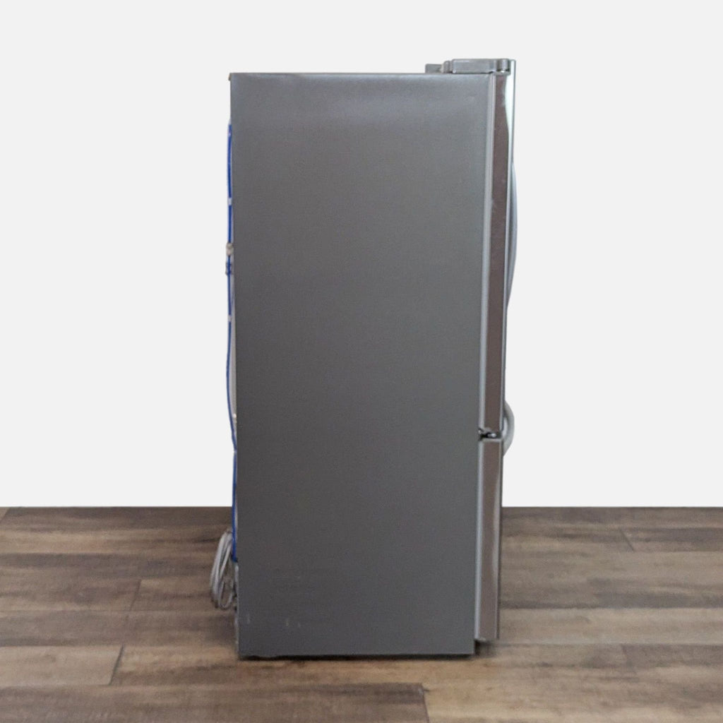 Profile of an LG stainless steel refrigerator seen from the side, showcasing its sleek design.