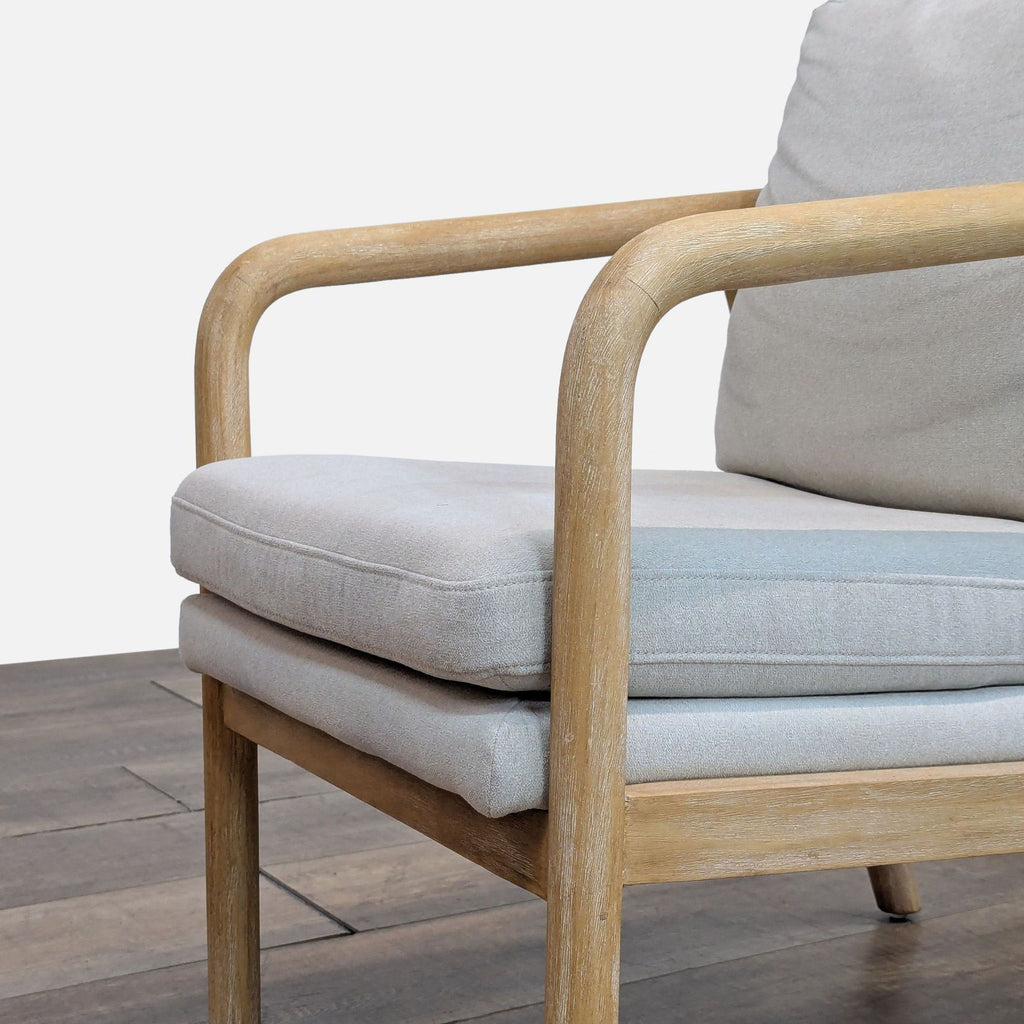 2. Close-up of Threshold lounge chair's wooden armrest and padded seat.