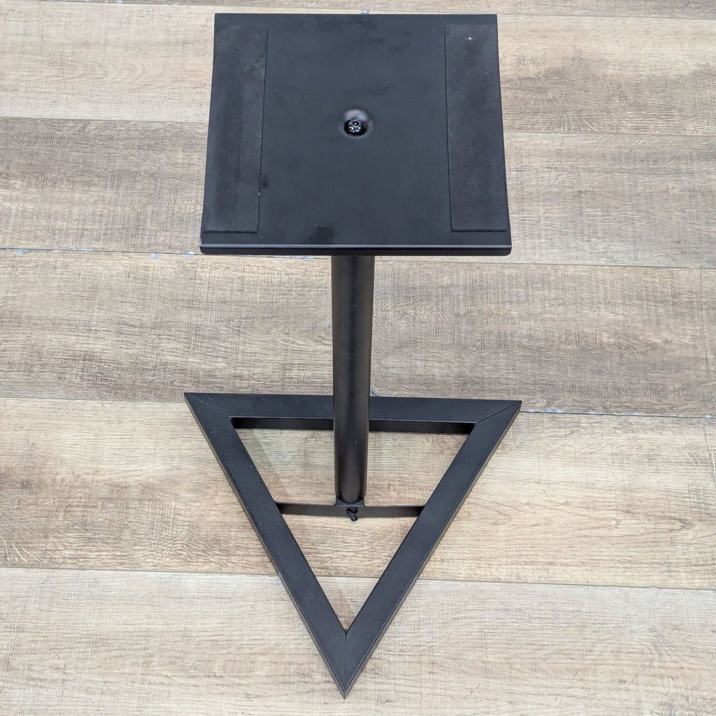 Top view of speaker stand with triangle base and flat platform.