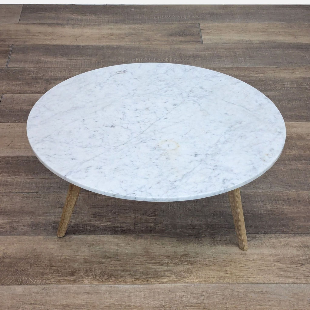 Round coffee table by Article featuring a marble top and solid oak legs.