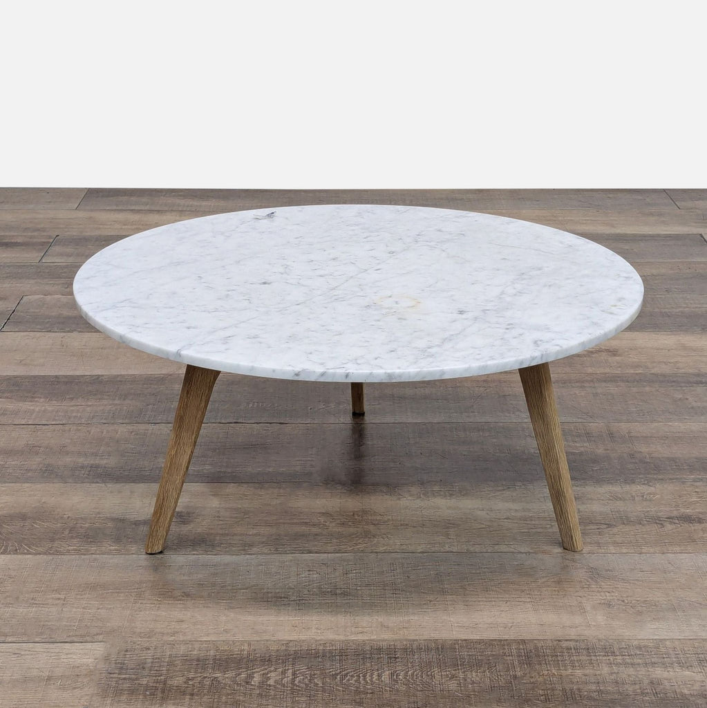 Article coffee table with a sleek marble top and sturdy oak legs.