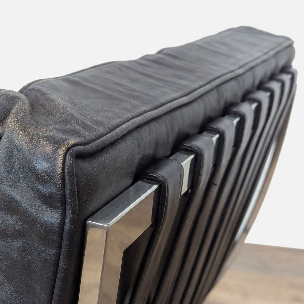 Close-up of the Barcelona chair's leather straps and polished steel frame.