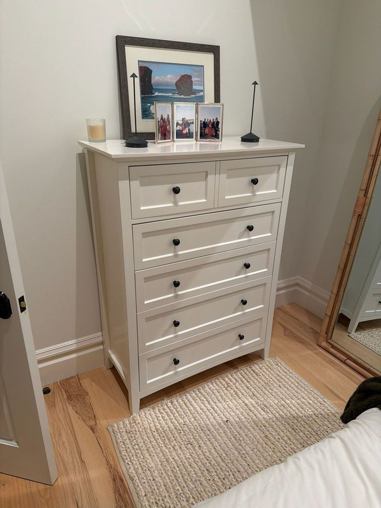 1. White Reperch dresser with six drawers, decorated with framed photos and art, placed in a cozy bedroom setting.