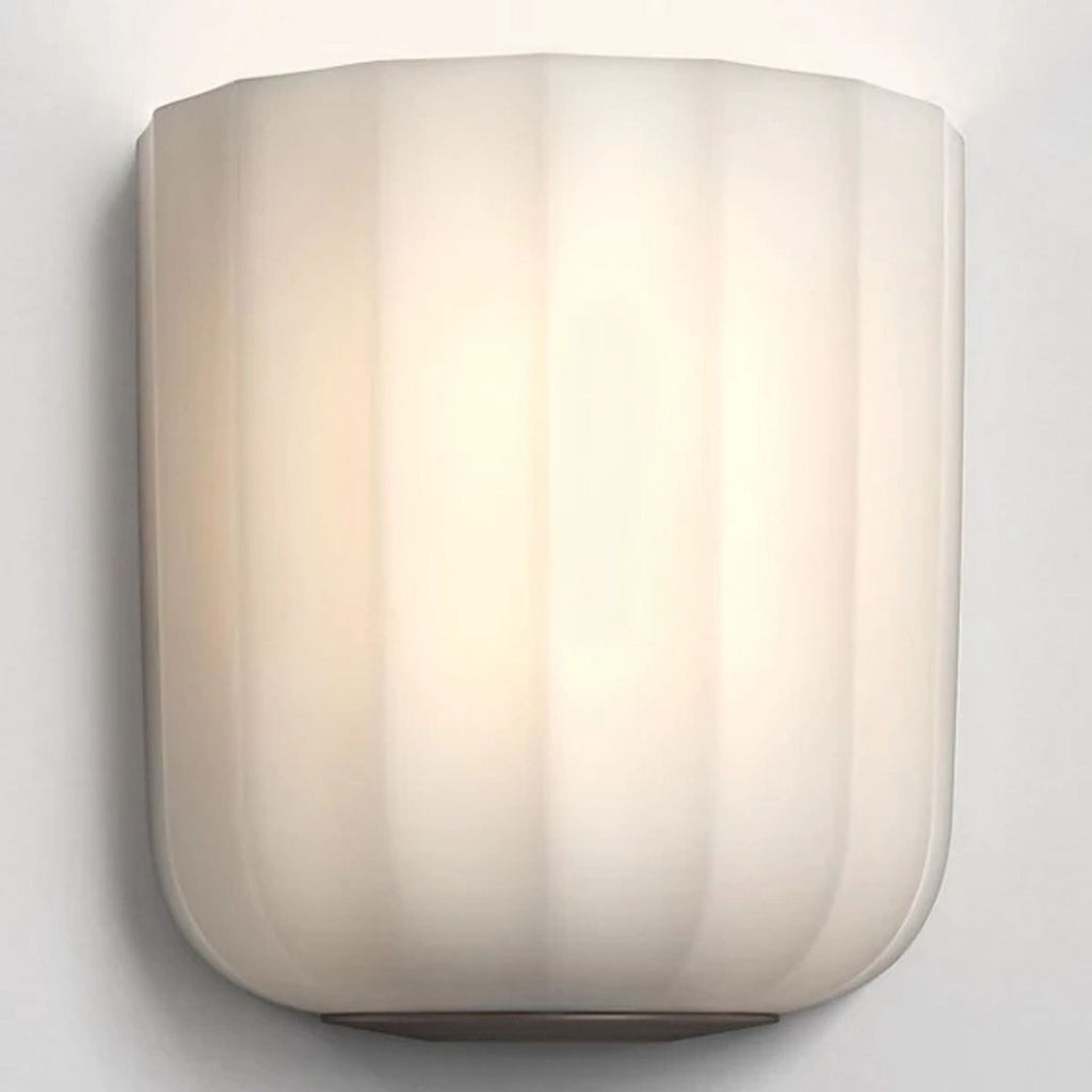 Fluted opal-glass wall light emits soft glow, with bronze base, by Astro.