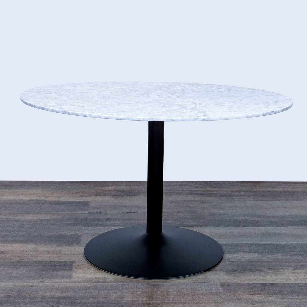 Round dining table by Coaster with white marble top and sleek black base.