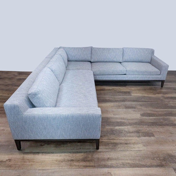 Modern sectional with track arms and textured fabric, elevated on oak wood base.  