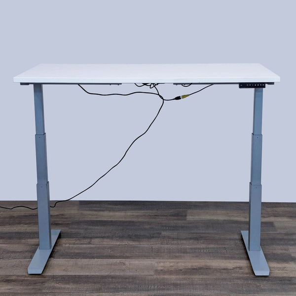 Adjustable height electric desk with white top from Reperch, viewed frontally on wooden floor.