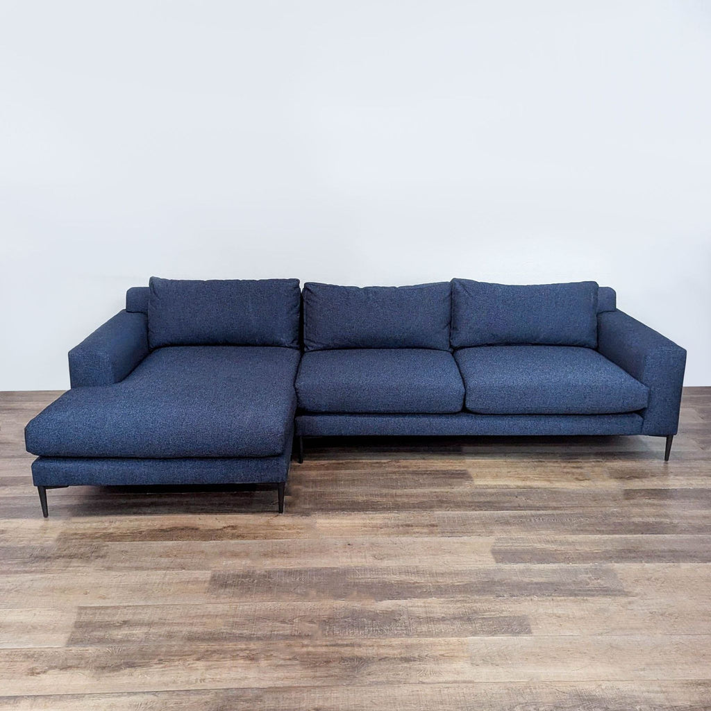 West Elm sectional with Scandinavian design in navy blue, features deep seats and metal legs.