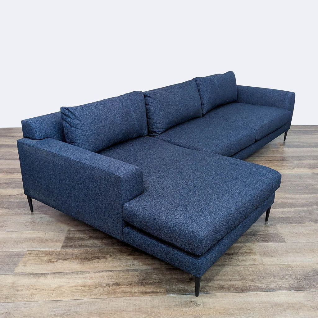 Scandinavian design navy sectional by West Elm, showcasing low profile and metal legs.