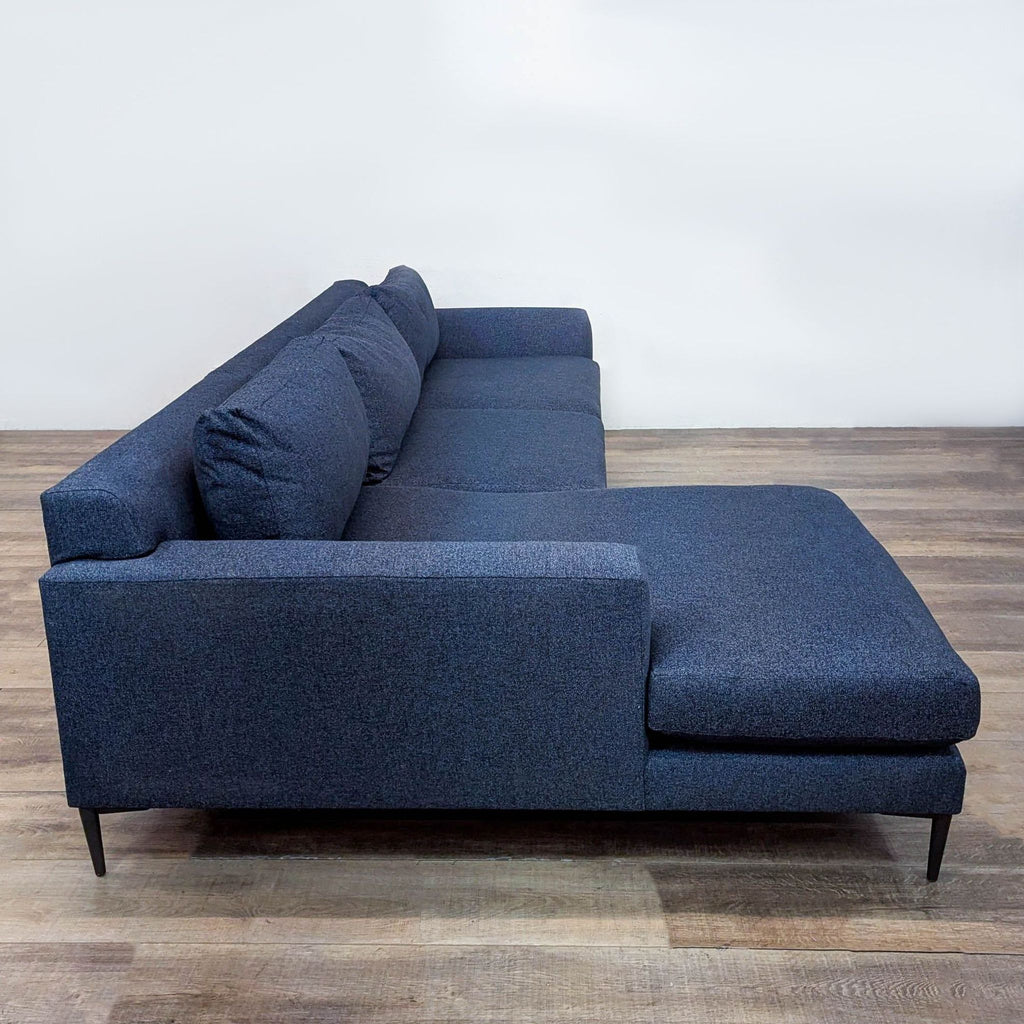 Modern navy West Elm sectional sofa with extra-deep seating and sleek metal legs.