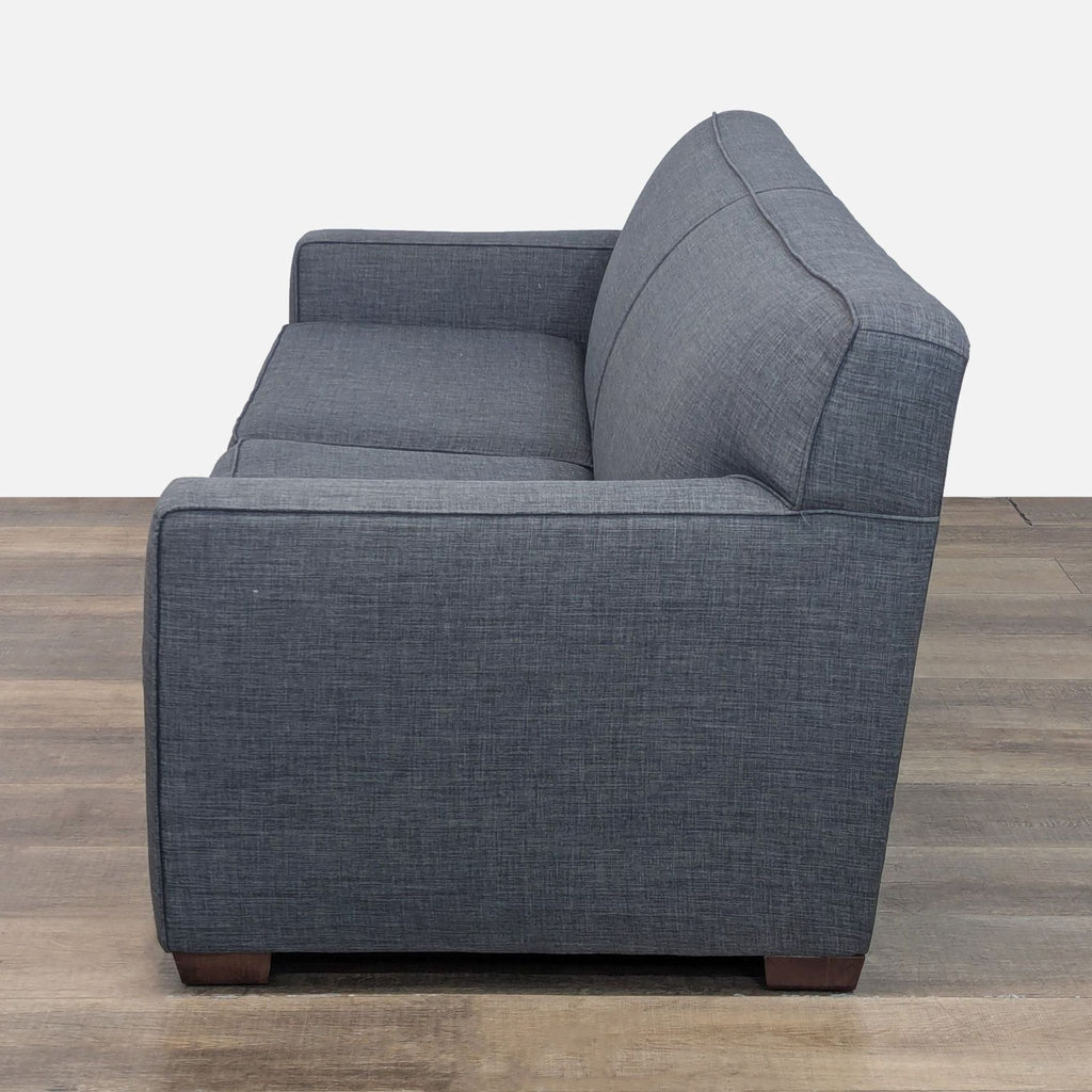 Side view of Reperch 3-seat sofa showcasing welted arms and boxed cushions on tapered wooden feet.