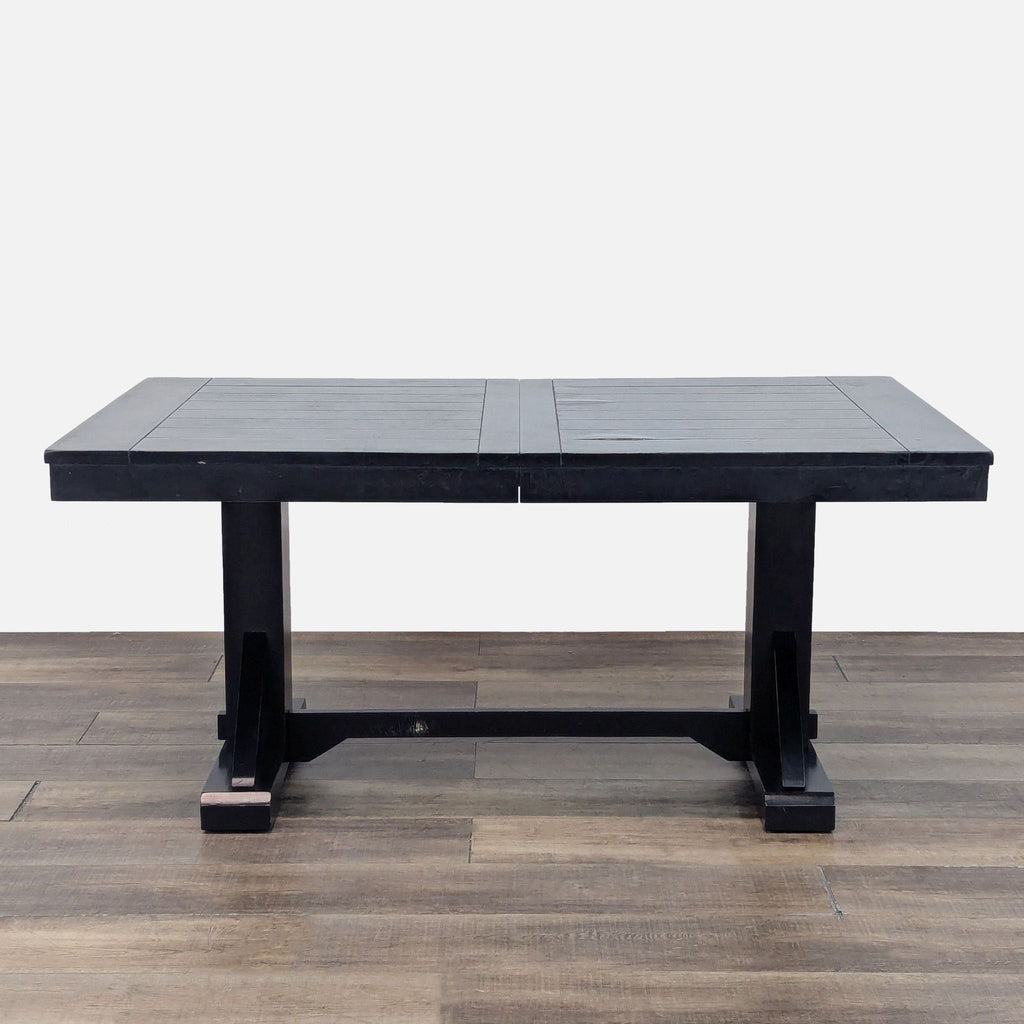 Cost Plus dining table in compact form, featuring a sleek trestle design on wooden flooring.