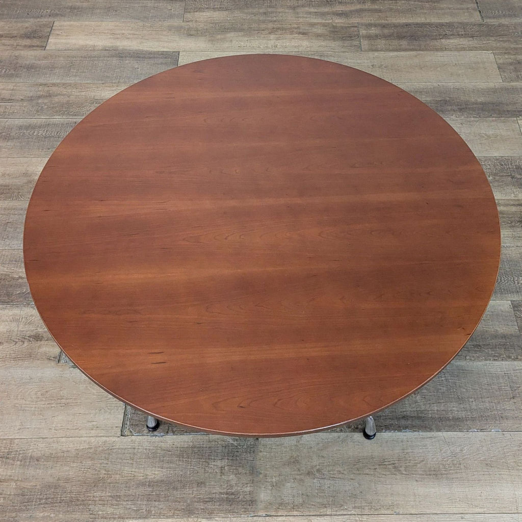 Top view of Eames Table with cherry finish, highlighting its smooth, circular walnut surface.