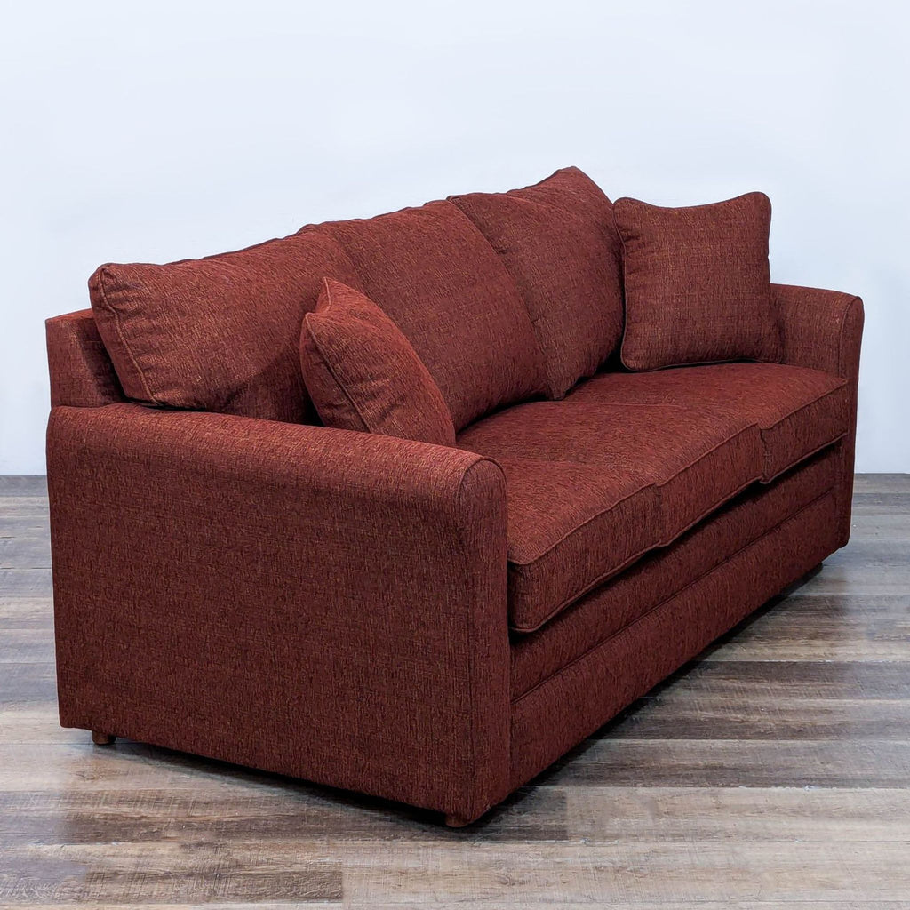 Angled view of Reperch red sleeper sofa highlighting its plush, textured upholstery.