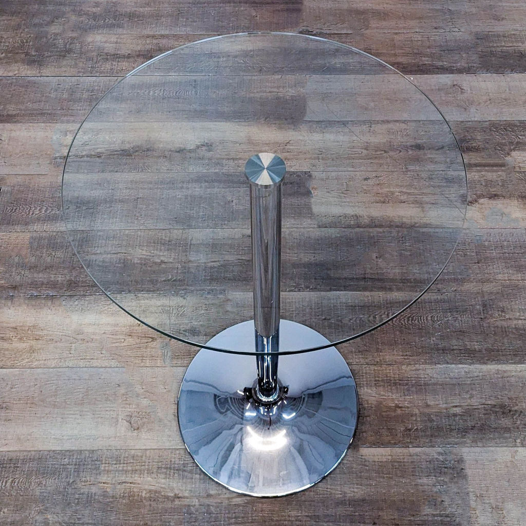 Top view of round glass table on metal base from Reperch, suitable for two.