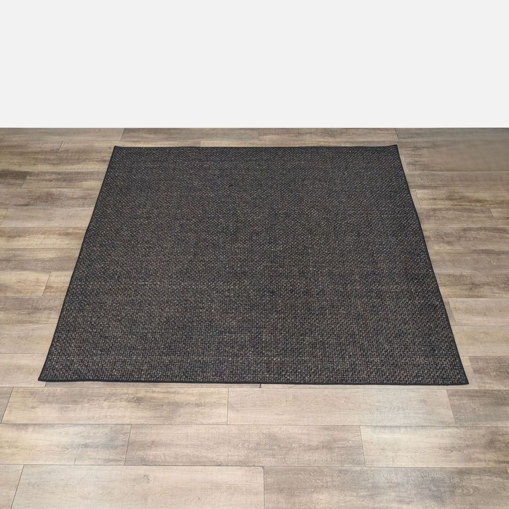 Sisal rug with a basket weave pattern by RH, shown on a wooden floor.