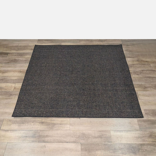 Sisal rug with a basket weave pattern by RH, shown on a wooden floor.