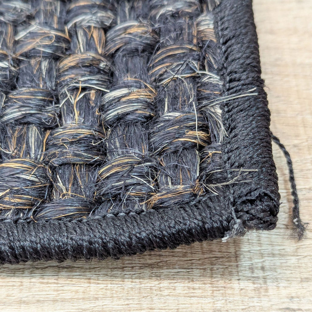Detailed view of a sisal rug corner, highlighting its weave and edge finish.