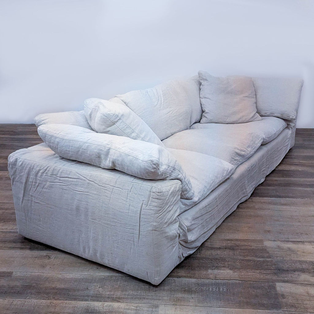 Side view of a Restoration Hardware 3-seater sofa with soft, feather-filled cushions and foam core.