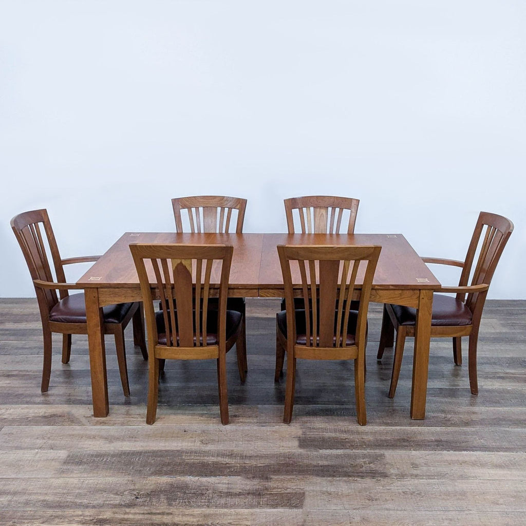 1. Stickley cherry dining set with six chairs, leather seats, and intricate wood inlays on the table corners.  
