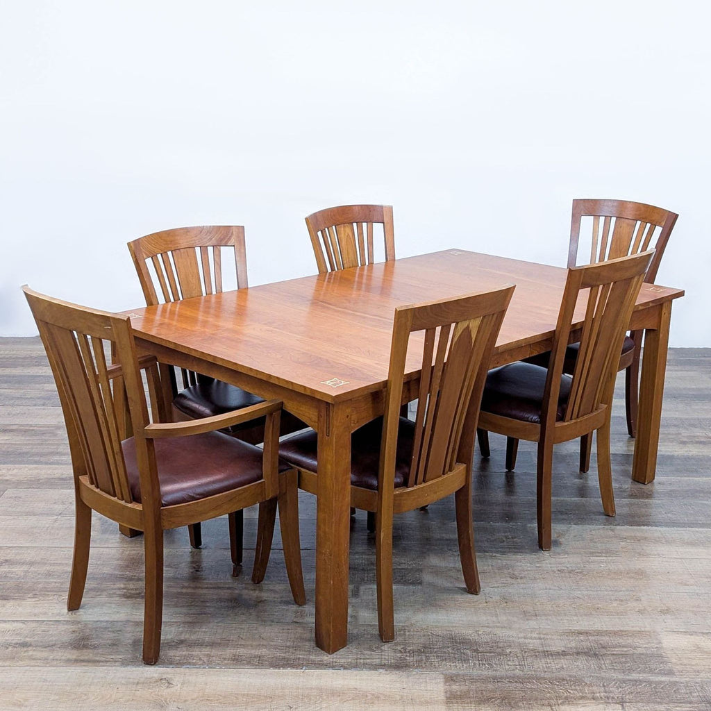 3. Stickley dining set featuring cherry wood table, exposed joinery, six slat-back chairs, and leather upholstery.