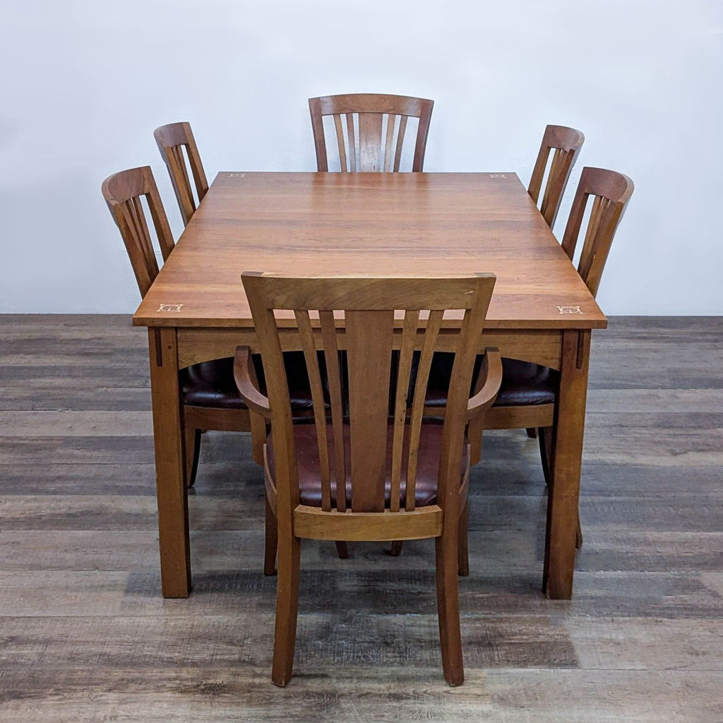 2. Rectangular cherry wood Stickley dining table, curved aprons, six leather chairs, and detailed inlays shown.  