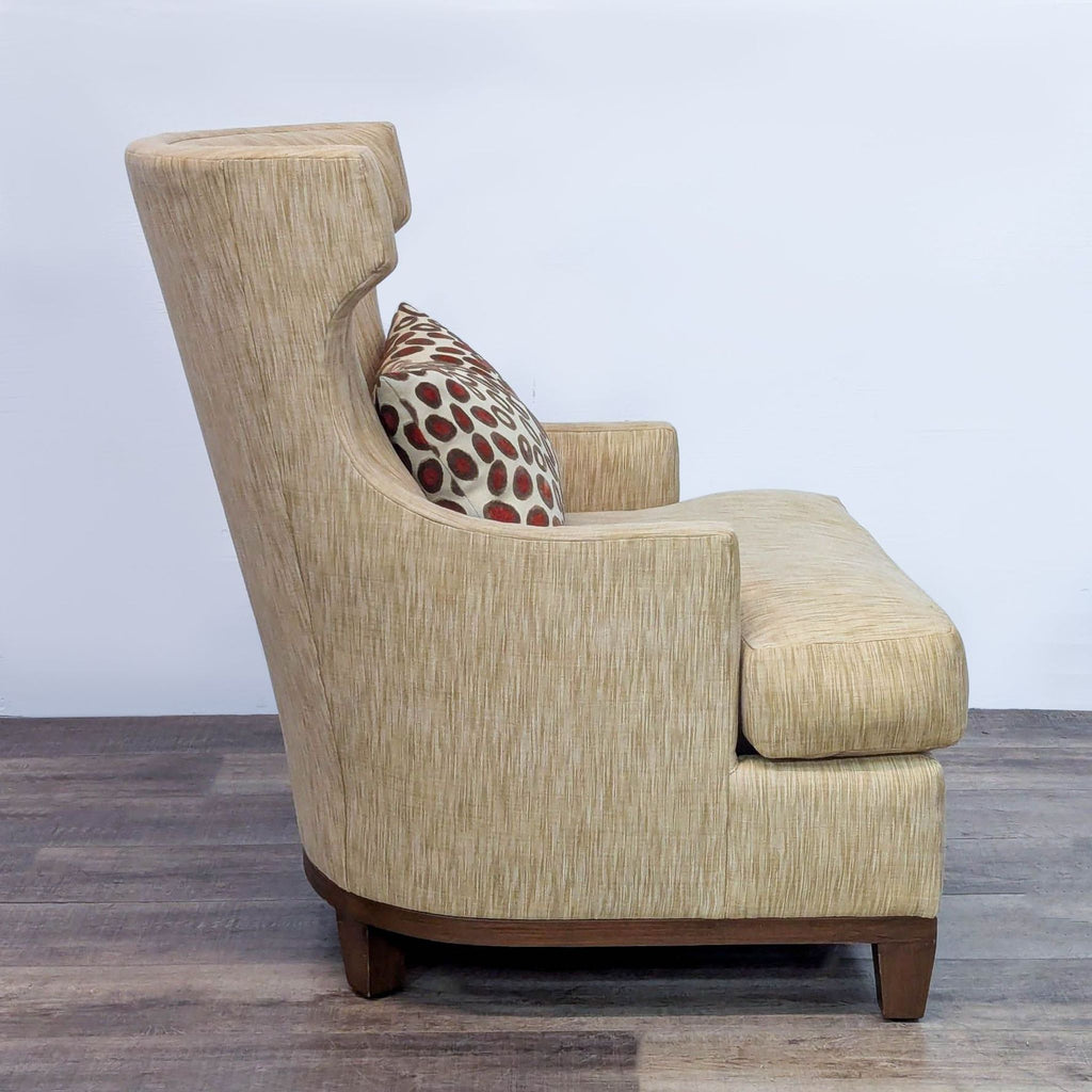 Side view of high wingback chair with curved back and cushion.