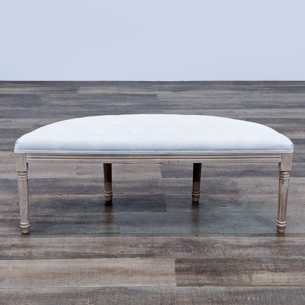 Solid wood bench with button-tufted linen cushion and grooved fluted legs, half-moon shape.