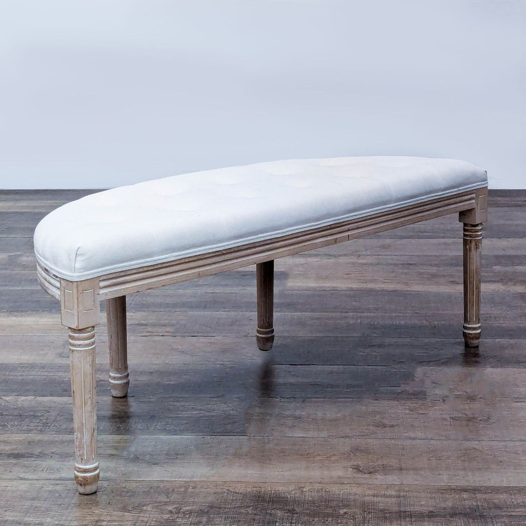 Half-moon bench with thick cushion, fluted legs, and button-tufted linen upholstery.