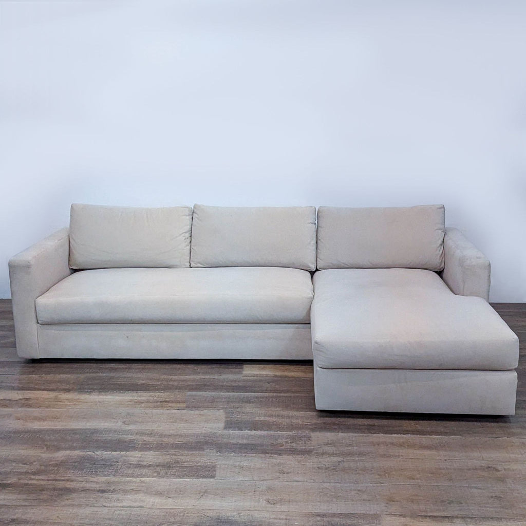 Cream velvet sectional sofa with chaise, soft and durable upholstery. Roomy seating on wooden floor.  
