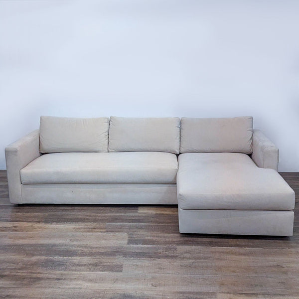Cream velvet sectional sofa with chaise, soft and durable upholstery. Roomy seating on wooden floor.  