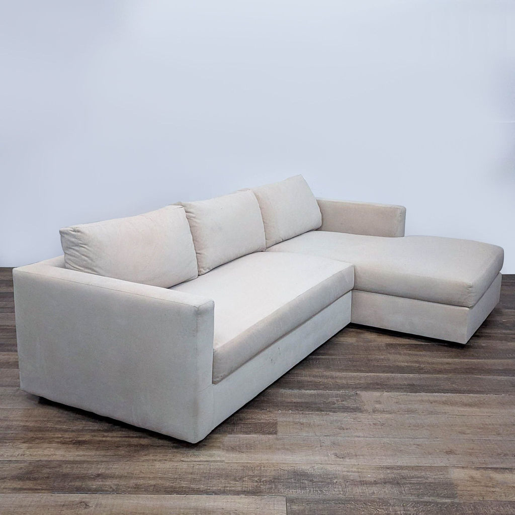 Three-seater cream velvet sectional with chaise, featuring plush cushions for relaxed elegance in any room.  