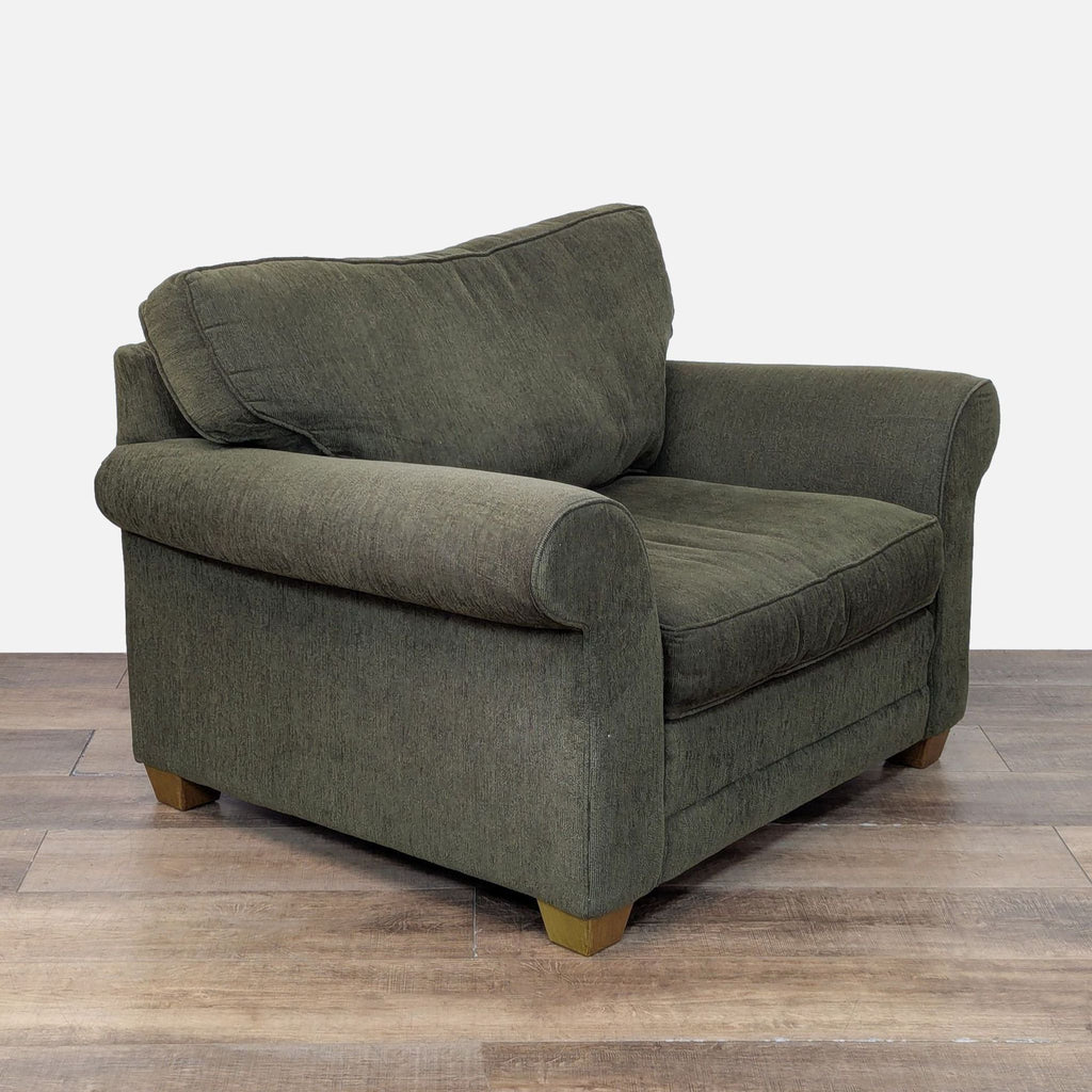 Cozy Bauhaus lounge chair with rolled arms, plush cushions, and tapered wooden feet.