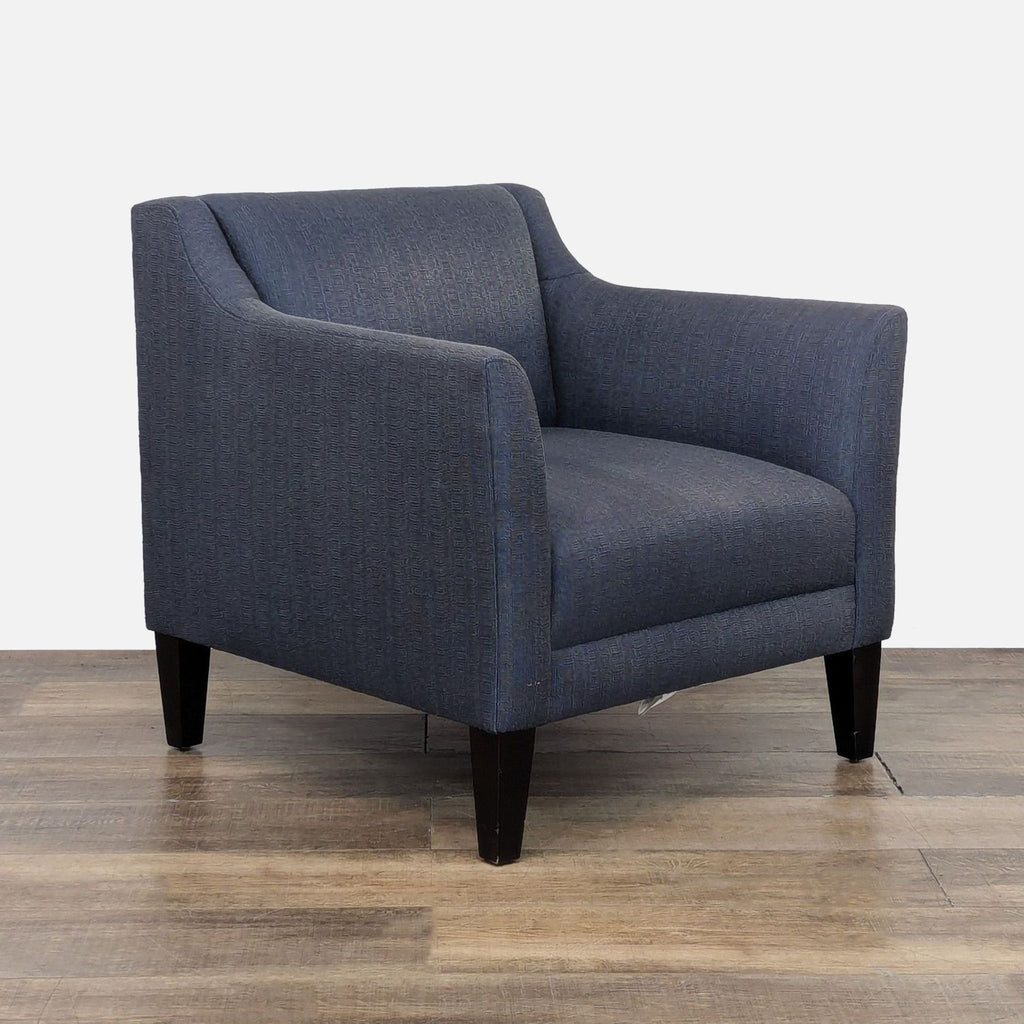3. Stylish blue armchair featuring tight back cushion, tapered legs, and cutaway arms from Crate & Barrel.