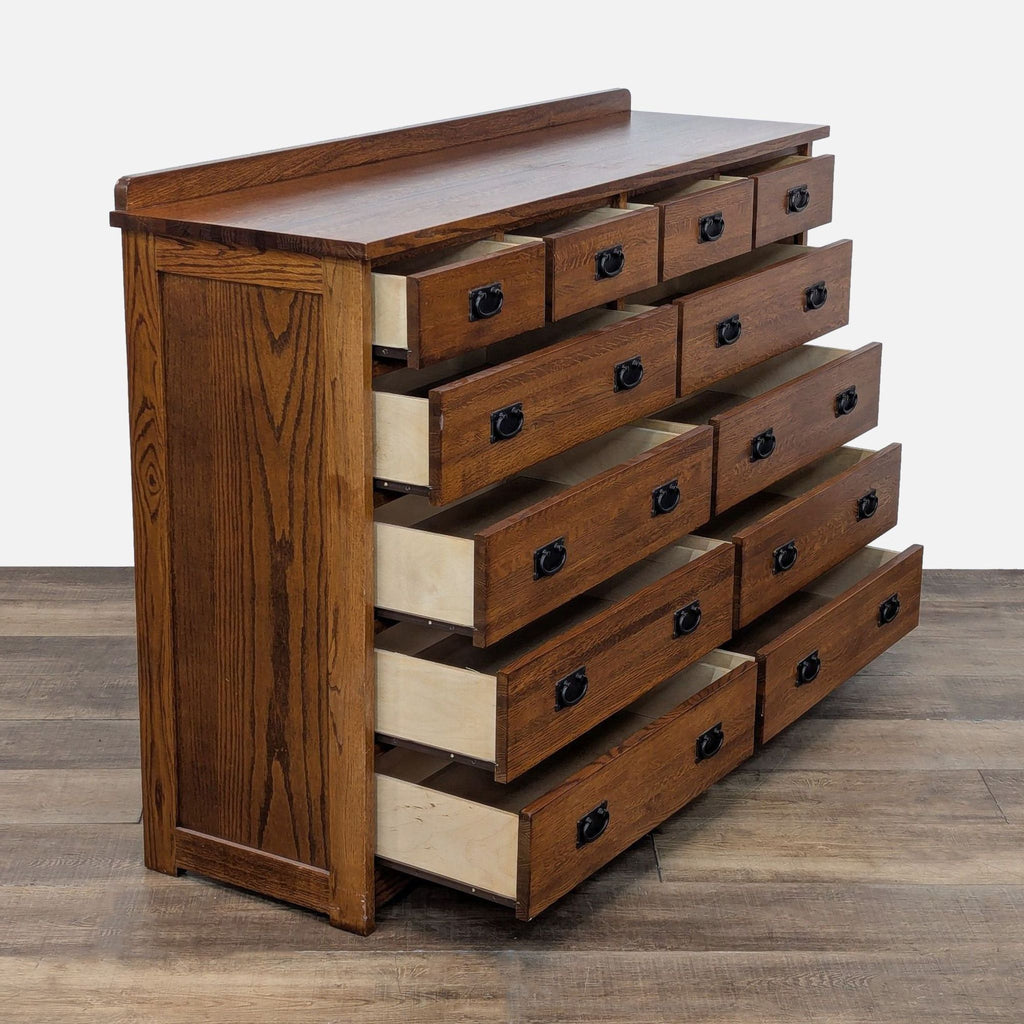 Open oak dresser showing 12 drawers with metal hardware and glides.