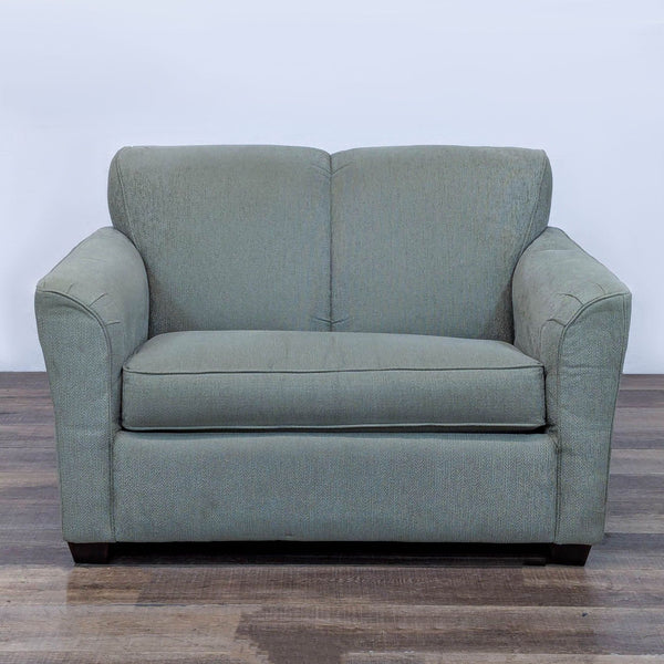 Sleeper sofa with channel-stitched back and flared arms in a greenish hue.