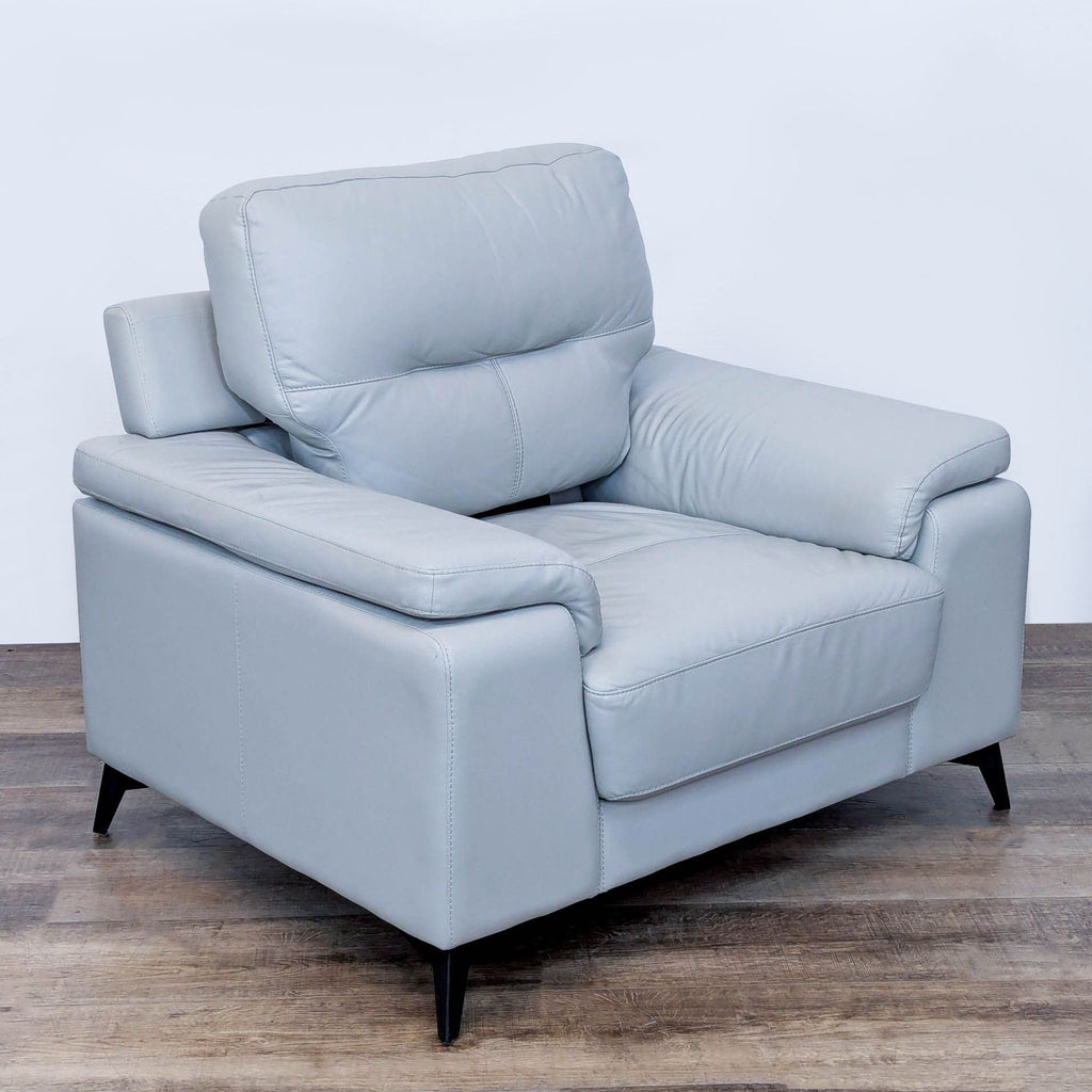 Angled view of the Homeglance Mischa chair, highlighting its pillow-top arms and black legs.
