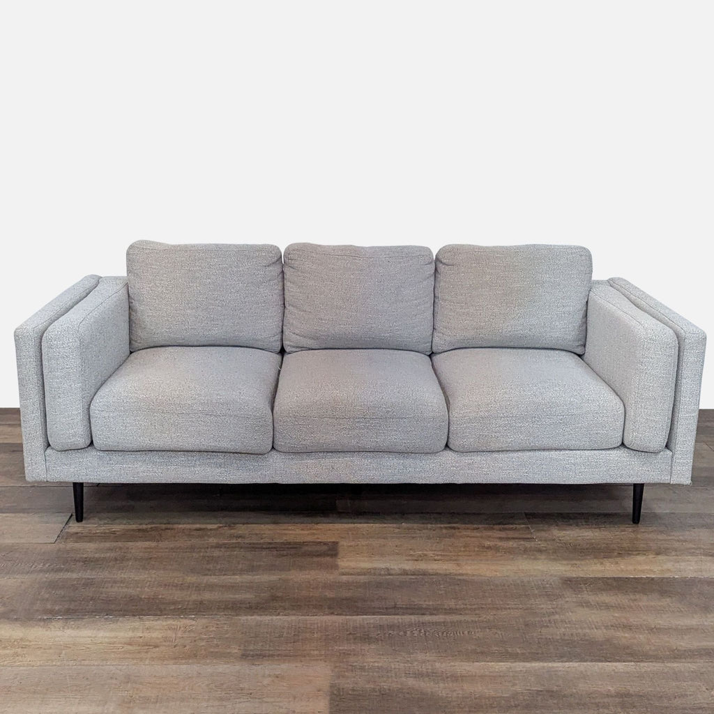 Front view of a 3-seat light gray sofa with track arms and tapered wood legs.