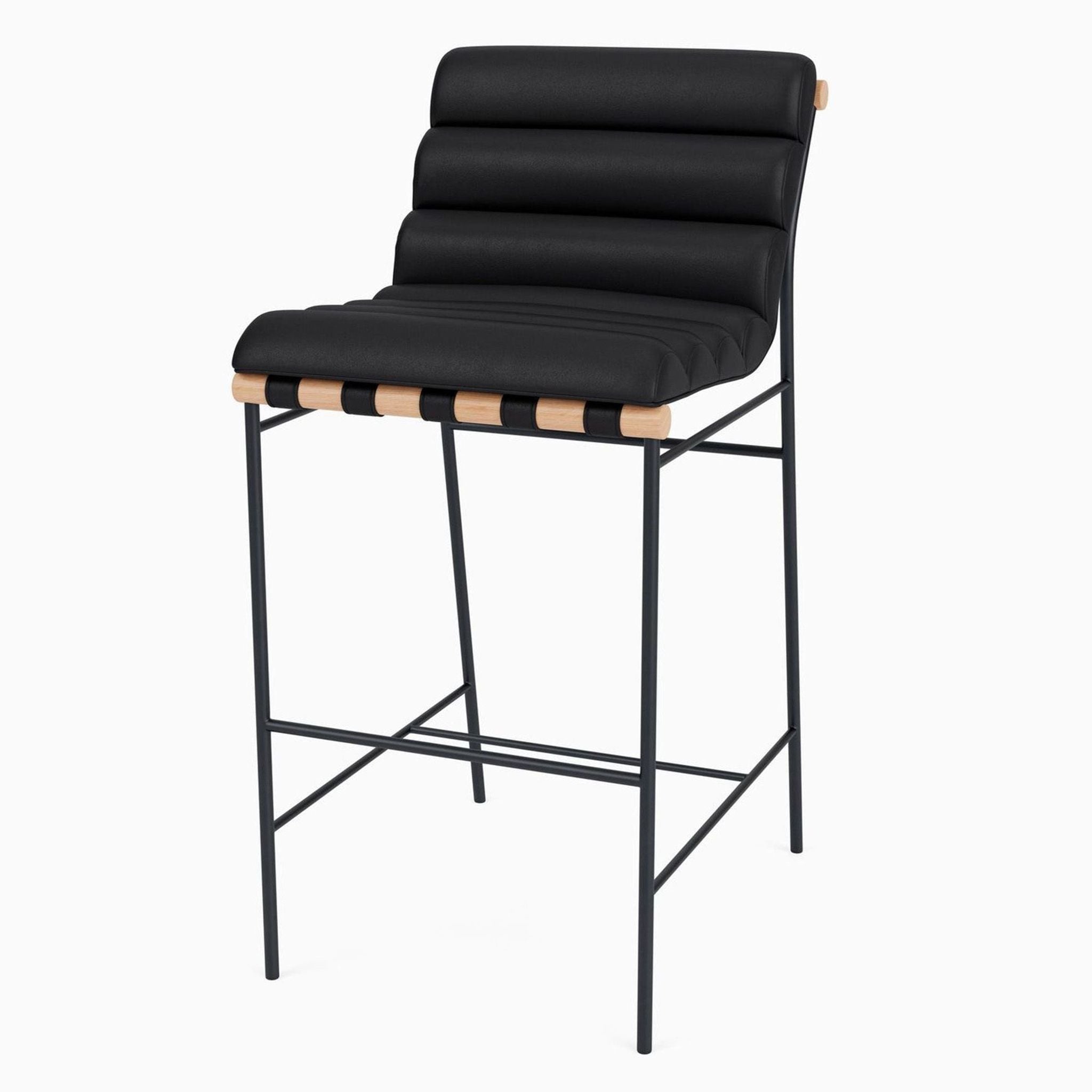 Side view of black leather stool with steel legs and oak elements.
