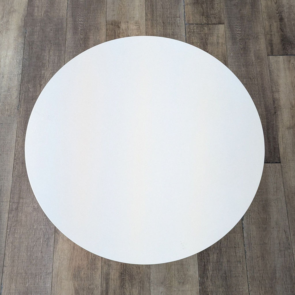Top view of West Elm's white round tripod table.